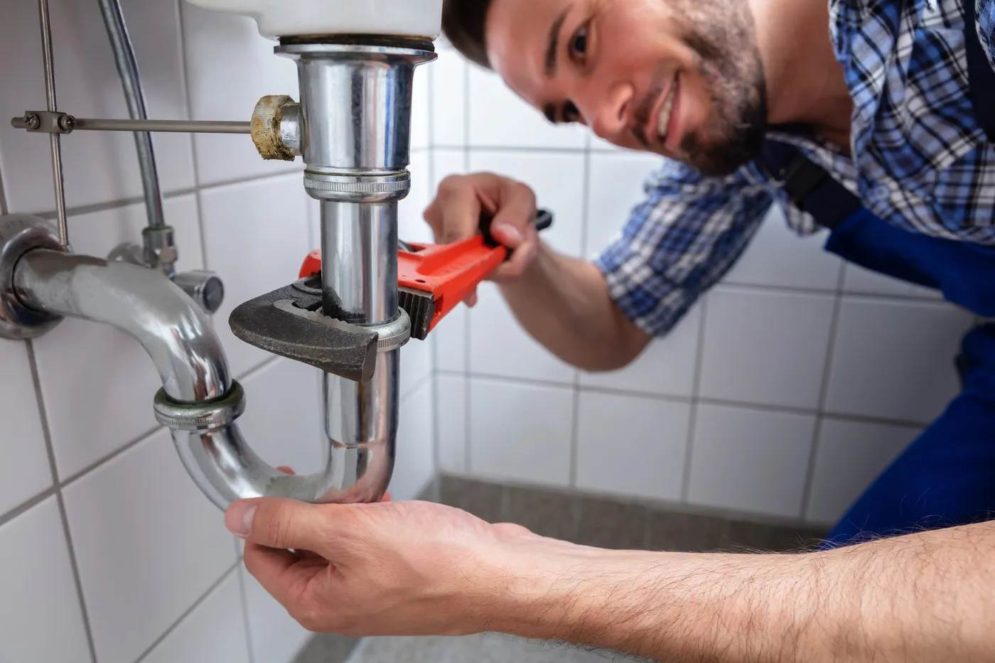 Raccordement d'un siphon sous un lavabo par un plombier dans le 77